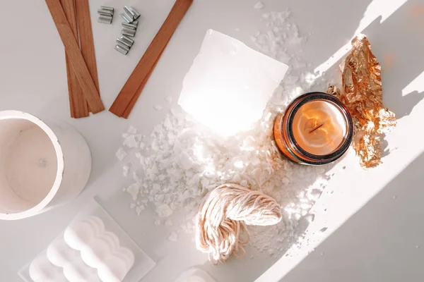 Handmade ecological and vegan soy wax candles with wooden wick. Amber and opaque container. Candle making utensils. Cruelty-free vegan product. Top view
