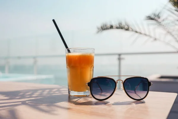 Glass Orange Juice Sunglasses Background Sea — Fotografia de Stock