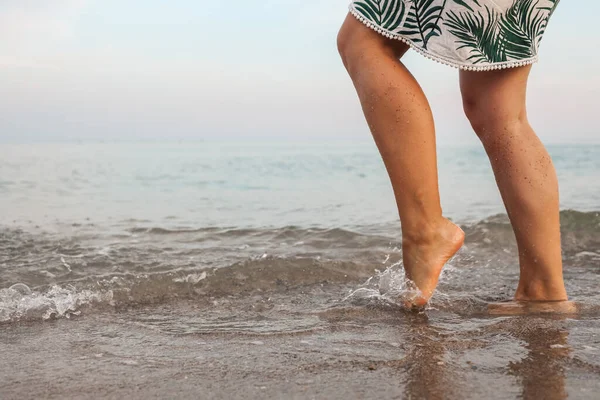 Woman feet walk slow life and relax on sand tropical beach with blue sky background. Vacation and holiday concept.