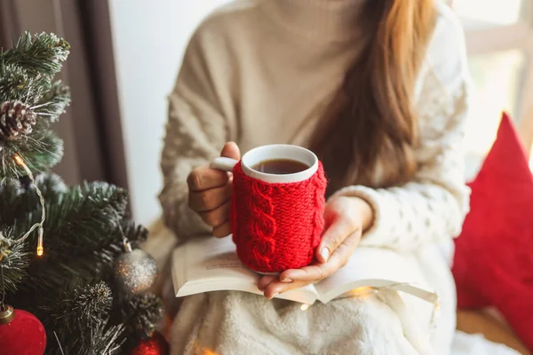 Girl Holds Book Knitted Red Cup Her Hands Christmas Mood — Zdjęcie stockowe