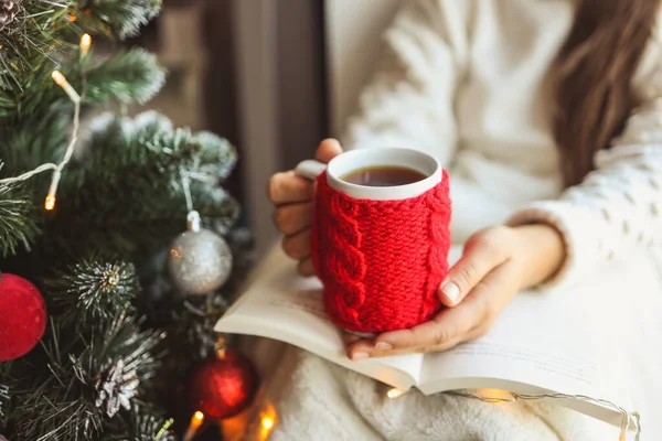 Girl Holds Book Knitted Red Cup Her Hands Christmas Mood — Zdjęcie stockowe