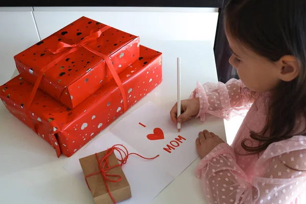 Happy Mother\'s Day! A little girl makes a postcard and gifts for mom.