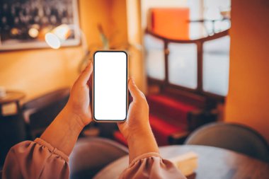 Close up of woman using cell phone,sending massages on the coffee shop