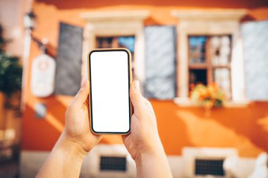 Phone in hand with a screen on the background of the city