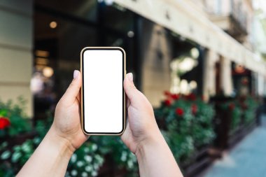 Phone in hand with a screen on the background of the city