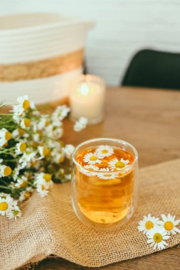 Glass cup of chamomile tea on the table
