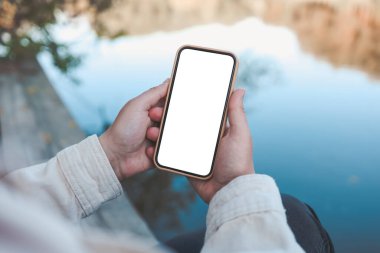 Phone with isolated screen on the background of the river.