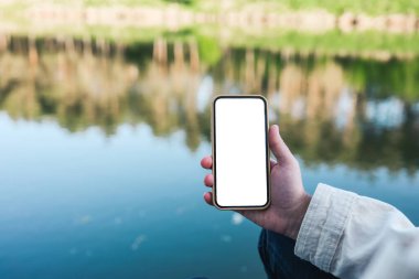 Phone with isolated screen on the background of the river.