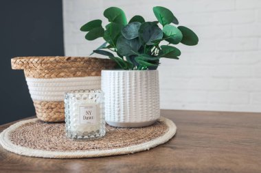 Home interior. Still life with detailes. Wicker basket with plants and candles on the kitchen table, the concept of cosiness. Close up.