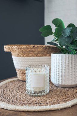 Room decor, candle, green plant and wicker basket, close-up interior details