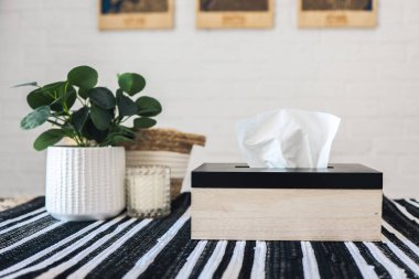 Napkin holder with napkins on the table, kitchen interior.