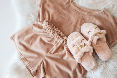 Home slippers and cozy pajamas on a fluffy white plaid
