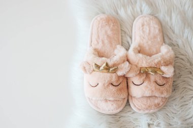 Home slippers on a white fluffy carpet