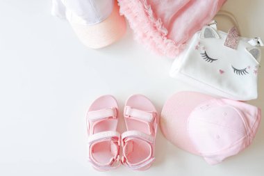 Set of summer children's clothing, flat lay top view. Sandals, caps, bag, skirt on a white isolated front.