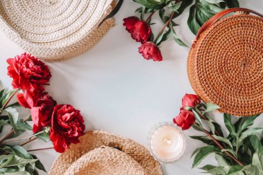 Flat lay set of summer accessories, wicker hat, bag, peonies, candle