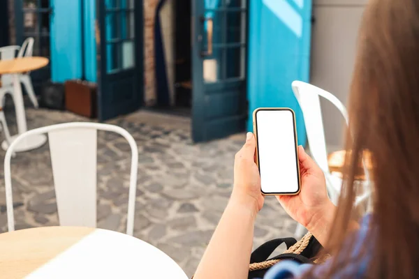 Girl with a screen phone in a cafe on the street