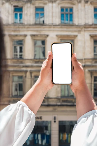 Girl with a phone with a screen in her hands against the background of an old building