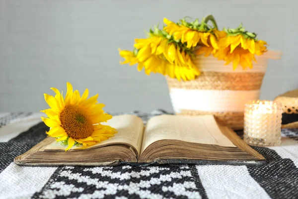Open old book on the table with sunflowers and candles, aesthetics and inspiration