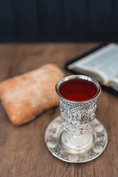 Christian communion, bread and wine on wooden background.