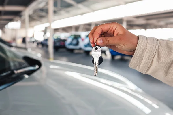 Keys in hand, car in the parking lot.