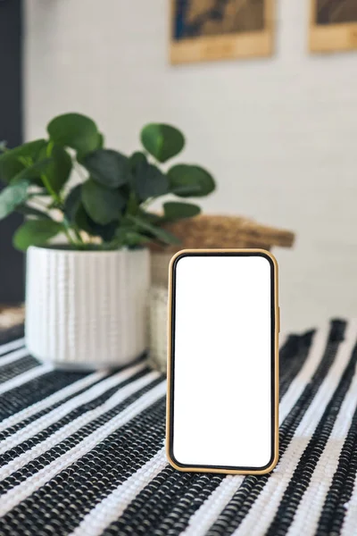 Phone with blank screen with place for your text on the table.