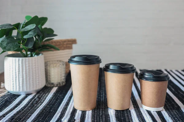 Three sizes of paper cups with coffee, cafe menu, space for your logo.