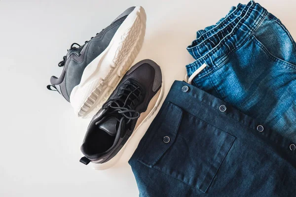 Stylish men's sneakers, jeans and jacket, flat lay top view