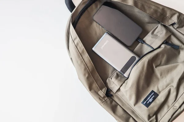 Mobile phone and power bank on a backpack.