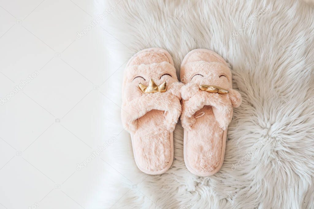 Home slippers on a white fluffy carpet