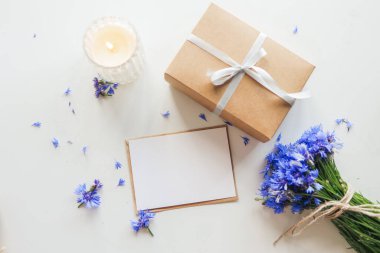 Postcard with empty text, gift and flowers