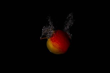 Taze meyve soğuk suya düşer ve hava kabarcıkları yüksek hızlı kameraya kısa süre içinde sağlıklı vejetaryen yaşam tarzını simgeler.