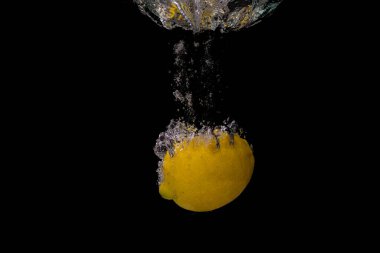 Taze meyve soğuk suya düşer ve hava kabarcıkları yüksek hızlı kameraya kısa süre içinde sağlıklı vejetaryen yaşam tarzını simgeler.