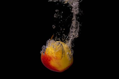 Taze meyve soğuk suya düşer ve hava kabarcıkları yüksek hızlı kameraya kısa süre içinde sağlıklı vejetaryen yaşam tarzını simgeler.