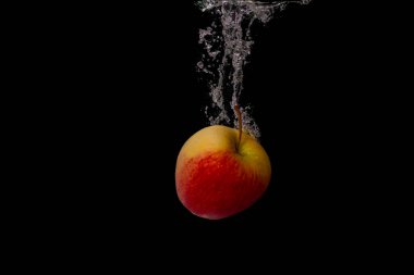 Taze meyve soğuk suya düşer ve hava kabarcıkları yüksek hızlı kameraya kısa süre içinde sağlıklı vejetaryen yaşam tarzını simgeler.