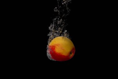 Taze meyve soğuk suya düşer ve hava kabarcıkları yüksek hızlı kameraya kısa süre içinde sağlıklı vejetaryen yaşam tarzını simgeler.