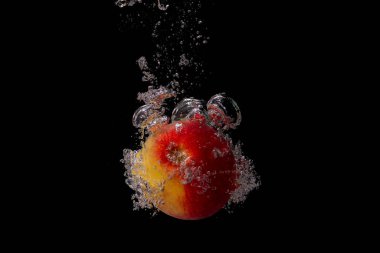 Taze meyve soğuk suya düşer ve hava kabarcıkları yüksek hızlı kameraya kısa süre içinde sağlıklı vejetaryen yaşam tarzını simgeler.