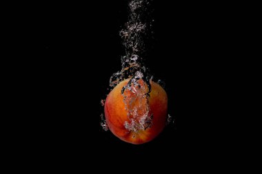 Taze meyve soğuk suya düşer ve hava kabarcıkları yüksek hızlı kameraya kısa süre içinde sağlıklı vejetaryen yaşam tarzını simgeler.