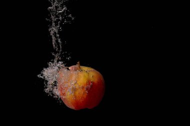 Taze meyve soğuk suya düşer ve hava kabarcıkları yüksek hızlı kameraya kısa süre içinde sağlıklı vejetaryen yaşam tarzını simgeler.