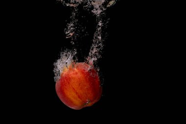 Taze meyve soğuk suya düşer ve hava kabarcıkları yüksek hızlı kameraya kısa süre içinde sağlıklı vejetaryen yaşam tarzını simgeler.