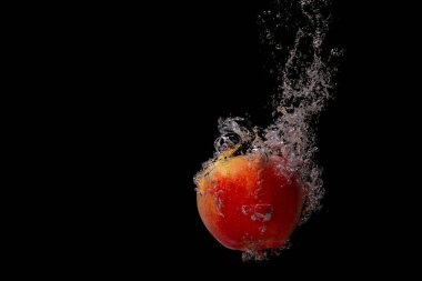 Taze meyve soğuk suya düşer ve hava kabarcıkları yüksek hızlı kameraya kısa süre içinde sağlıklı vejetaryen yaşam tarzını simgeler.