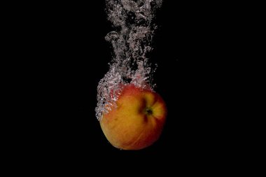 Taze meyve soğuk suya düşer ve hava kabarcıkları yüksek hızlı kameraya kısa süre içinde sağlıklı vejetaryen yaşam tarzını simgeler.