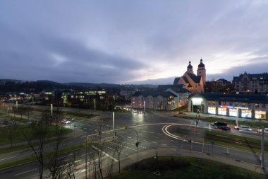 Plauen şehrindeki bir kilisenin önünde gece sokakta renkli çizgili arabaların olduğu bir yer.