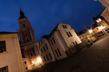 Plauen şehrindeki bir kilisenin önünde gece sokakta renkli çizgili arabaların olduğu bir yer.