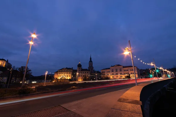 colorful light stripes of cars on the street at night in front of a church in the city of plauen