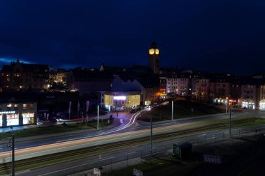 Plauen şehrindeki bir kilisenin önünde gece sokakta renkli çizgili arabaların olduğu bir yer.