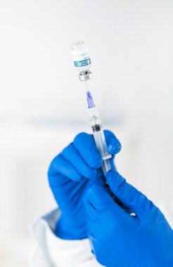 Doktor iğneye aşı hazırlıyor.