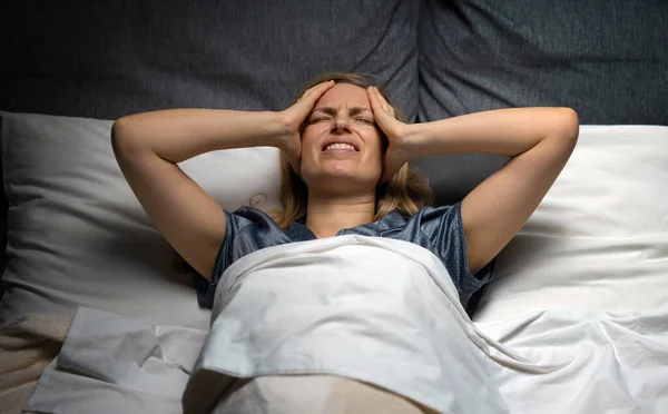 Geceleri başı ağrıyan bir kadın — Stok fotoğraf