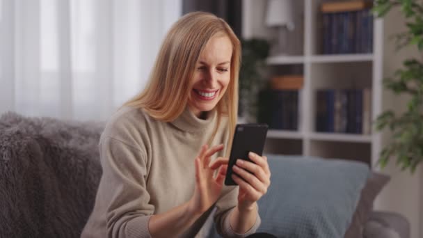 Kobieta korzystająca z telefonu komórkowego na kanapie — Wideo stockowe