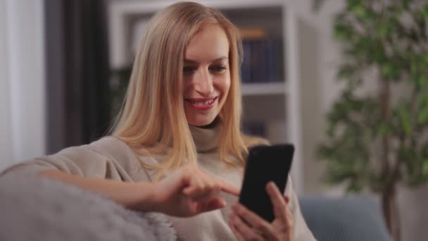 Mujer en el sofá con smartphone — Vídeo de stock