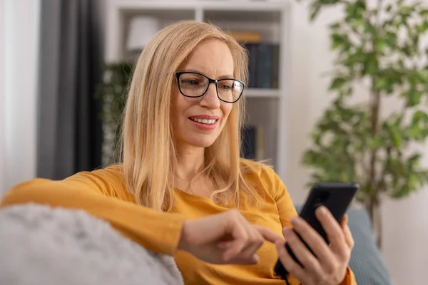 Kanepede cep telefonu olan kadın.